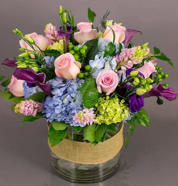 light pink roses with dark purple accents and blue and green hydrangea