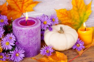 purple lit candle with white pumpkin