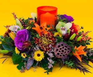 red candle with purple and yellow flowers