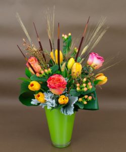 peach colored roses, yellow tulips and pink berries accented with cat tails and greenery