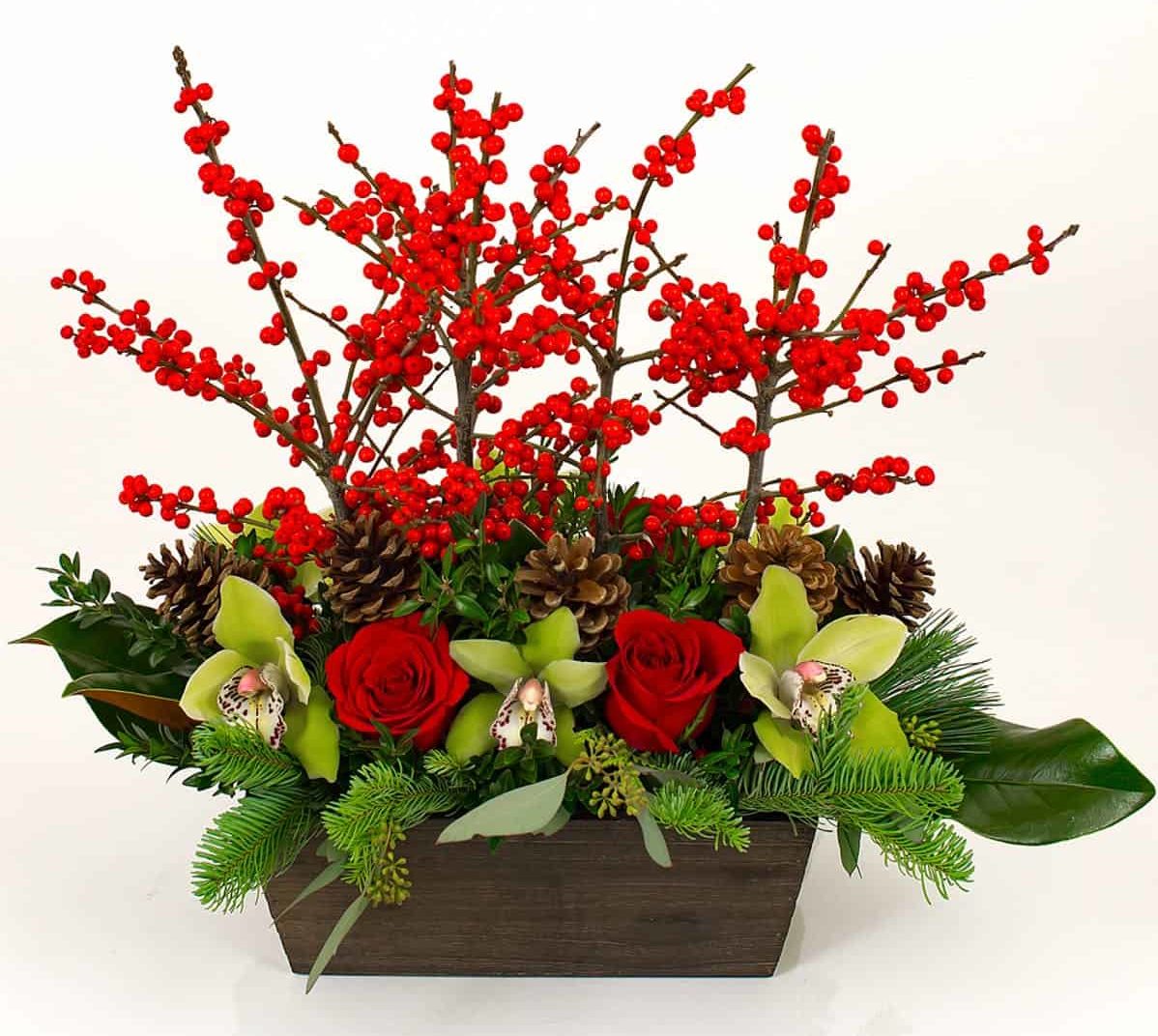 Rustic Winter Centerpiece combines the rustic feel of berries and a wooden container with more contemporary choices like cymbidium orchids and orchids.
