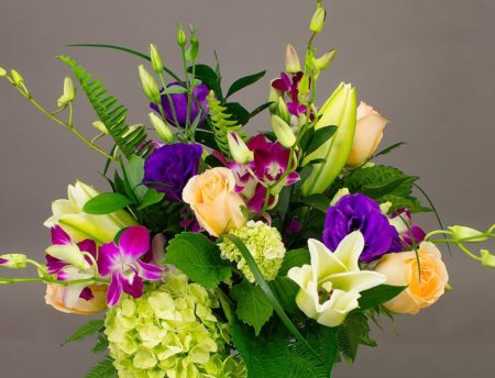 Purple dendrobium orchids are set in contrast with peach roses and green hydrangea. Just bursting with life and, as the title suggests, “For Love!” This arrangement will warm the heart of its lucky recipient.