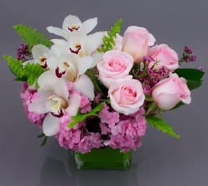 One of our best sellers, the Gentle Embrace is a sweet vase perfect for almost any occasion. It's compact design style makes it the perfect gift for home or office. The soft and subtle colors are easy on the eye and complement any decor. We've collected beautiful hydrangea, farm fresh premium roses and elegant cymbidium orchids and designed them in our signature cubes for easy transport.